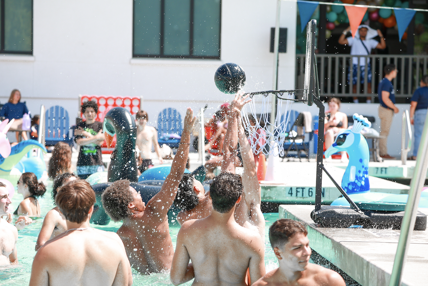 First years gather in the shallow end to play pick-up basketball in the pool during the Weekend of Welcome Pool Party on August 24, 2024. / Photo by Ashleen Rai ‘26