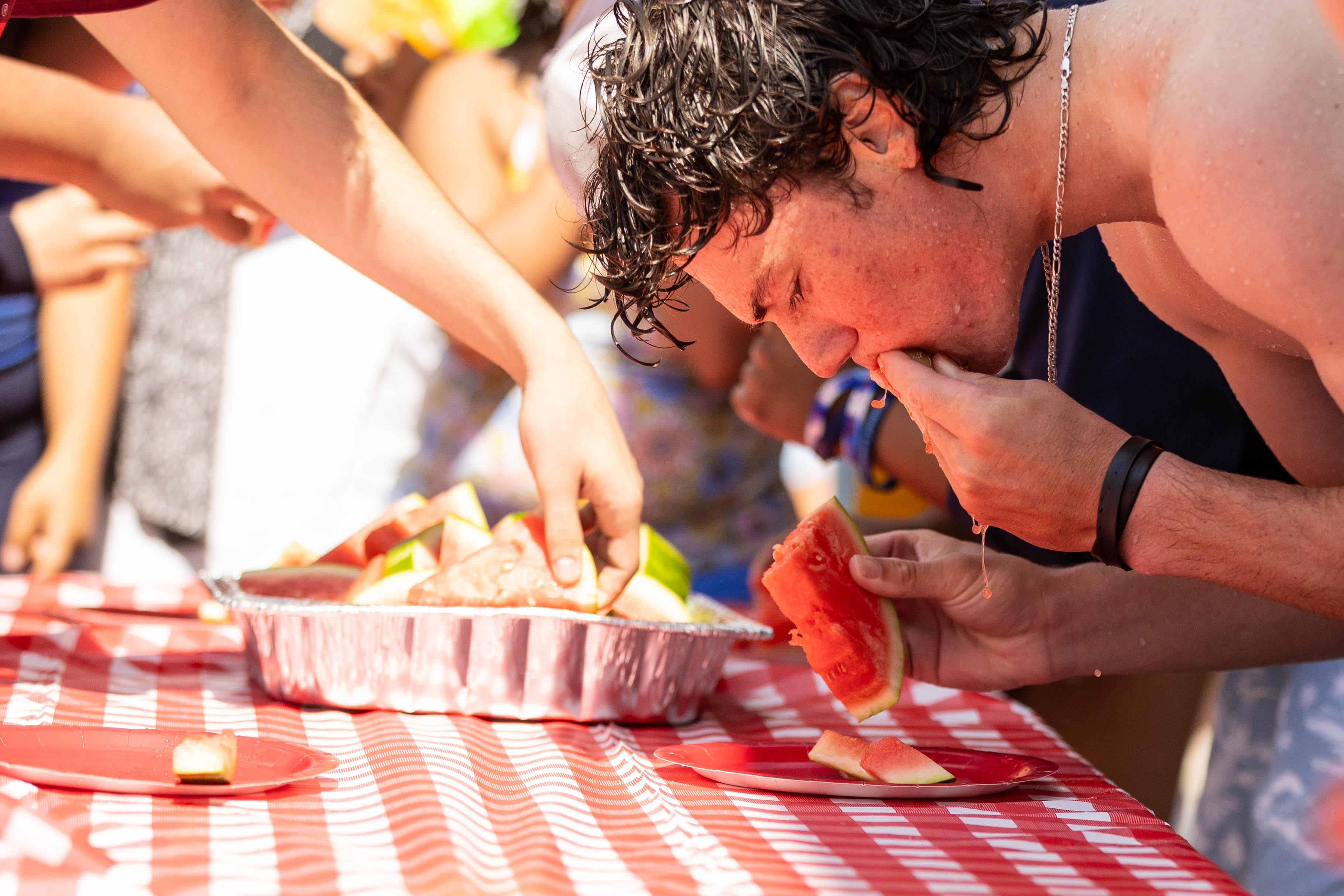 Juicy Mess: First Year student Ian Armstrong ‘28 attempts to eat the most amount of watermelon during the contest at the Weekend of Welcome Pool Party. / Photo by Rebecca Harper