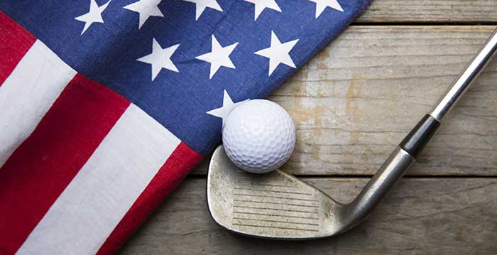 Picture of golf club and ball next to American flag