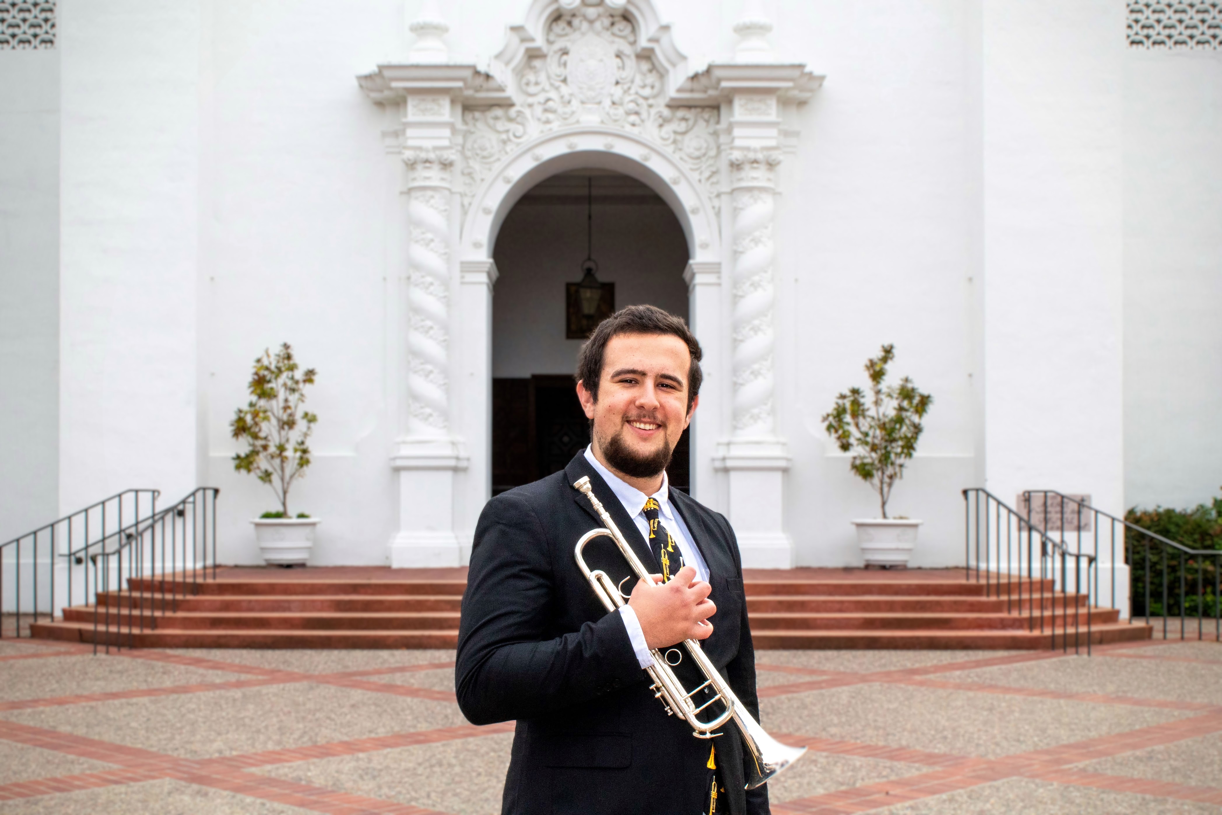 Nick Kaye '25 with his trumpet in front of the SMC Chapel