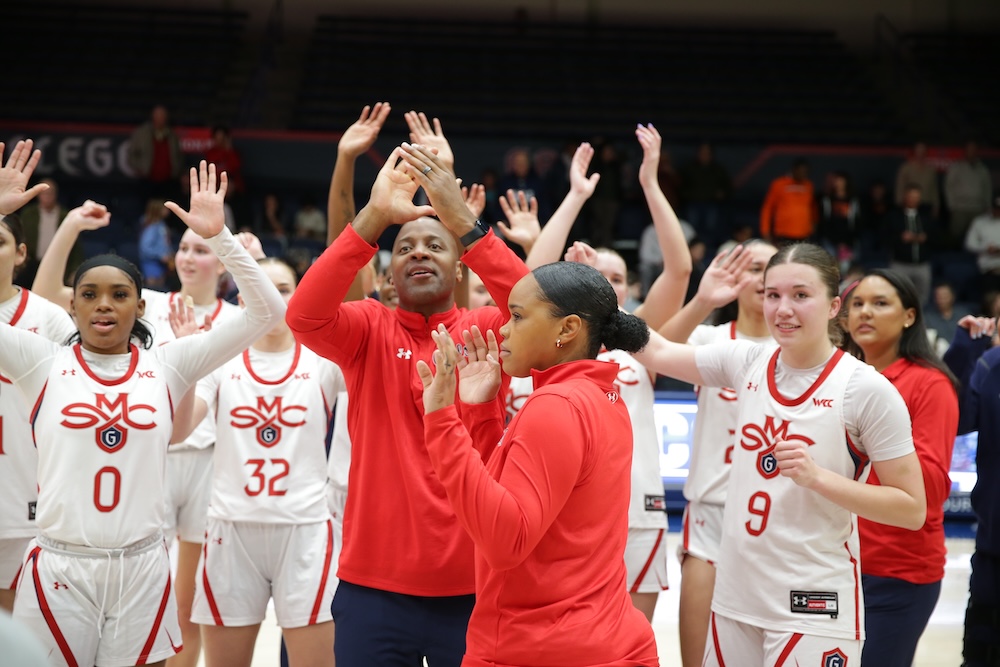 Women's basketball coach Jeff Cammon and players celebrate a win over Oregon State in February 2025