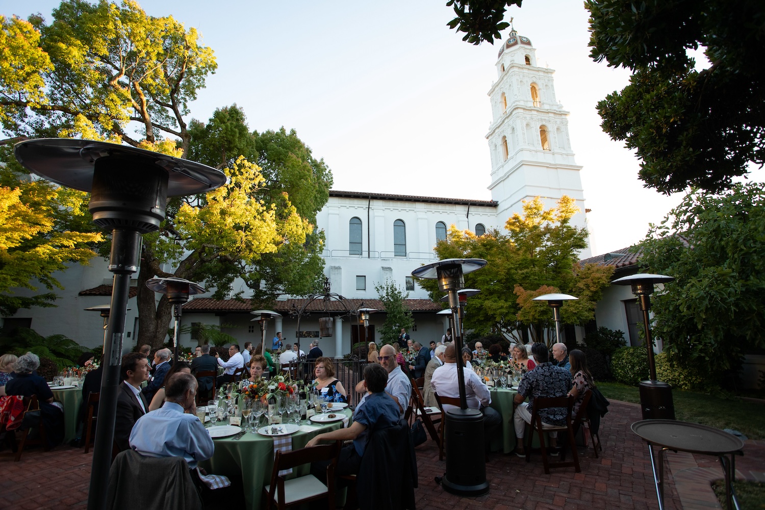 Seated dinner with fine florals in a courtyard under the chapel tower