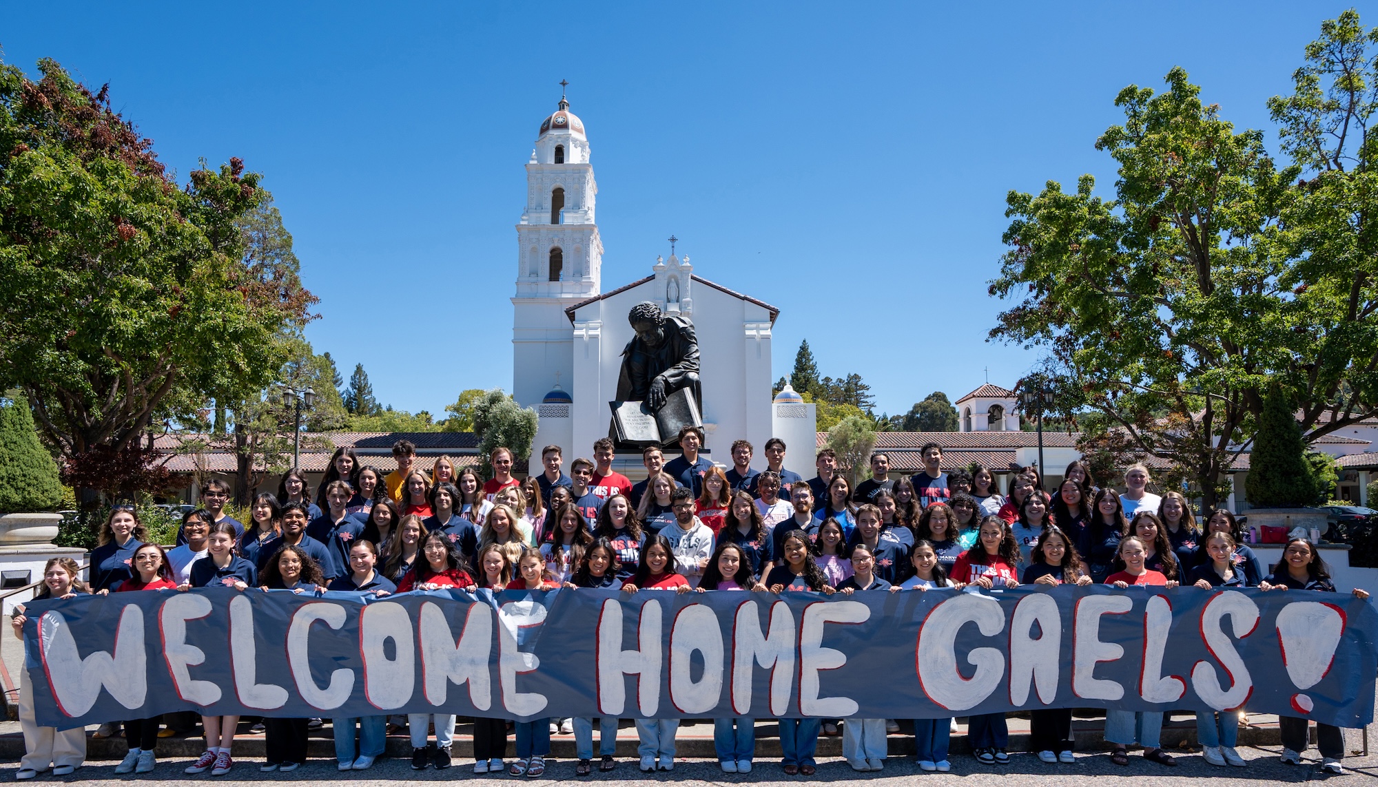 Students in front of Chapel with sign WELCOME HOME GAELS