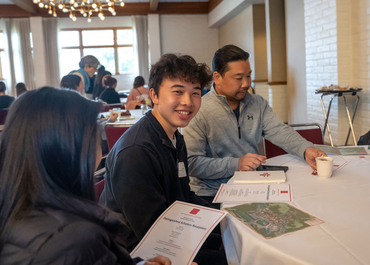 A student and parents sitting at a table at the Scholarship Reception