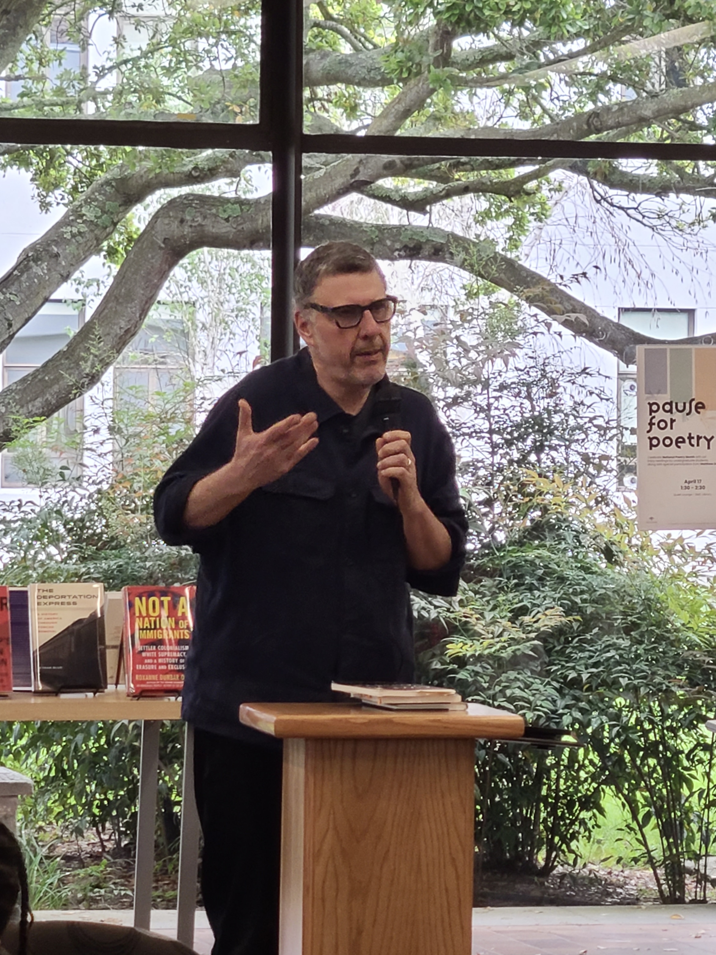 Matthew Zapruder speaking into a microphone and gesturing