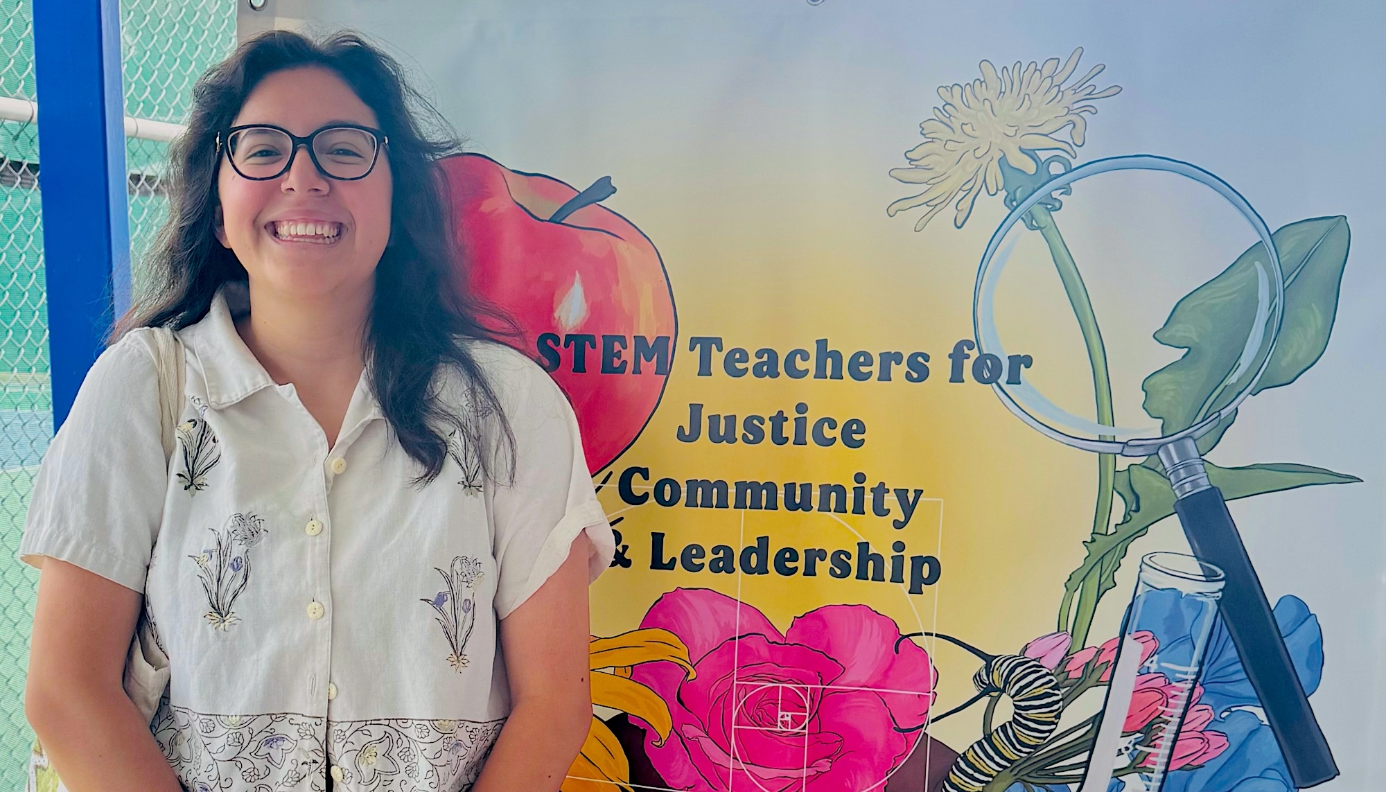 Xochilt Delgado Noyce Scholar in front of wall with mural