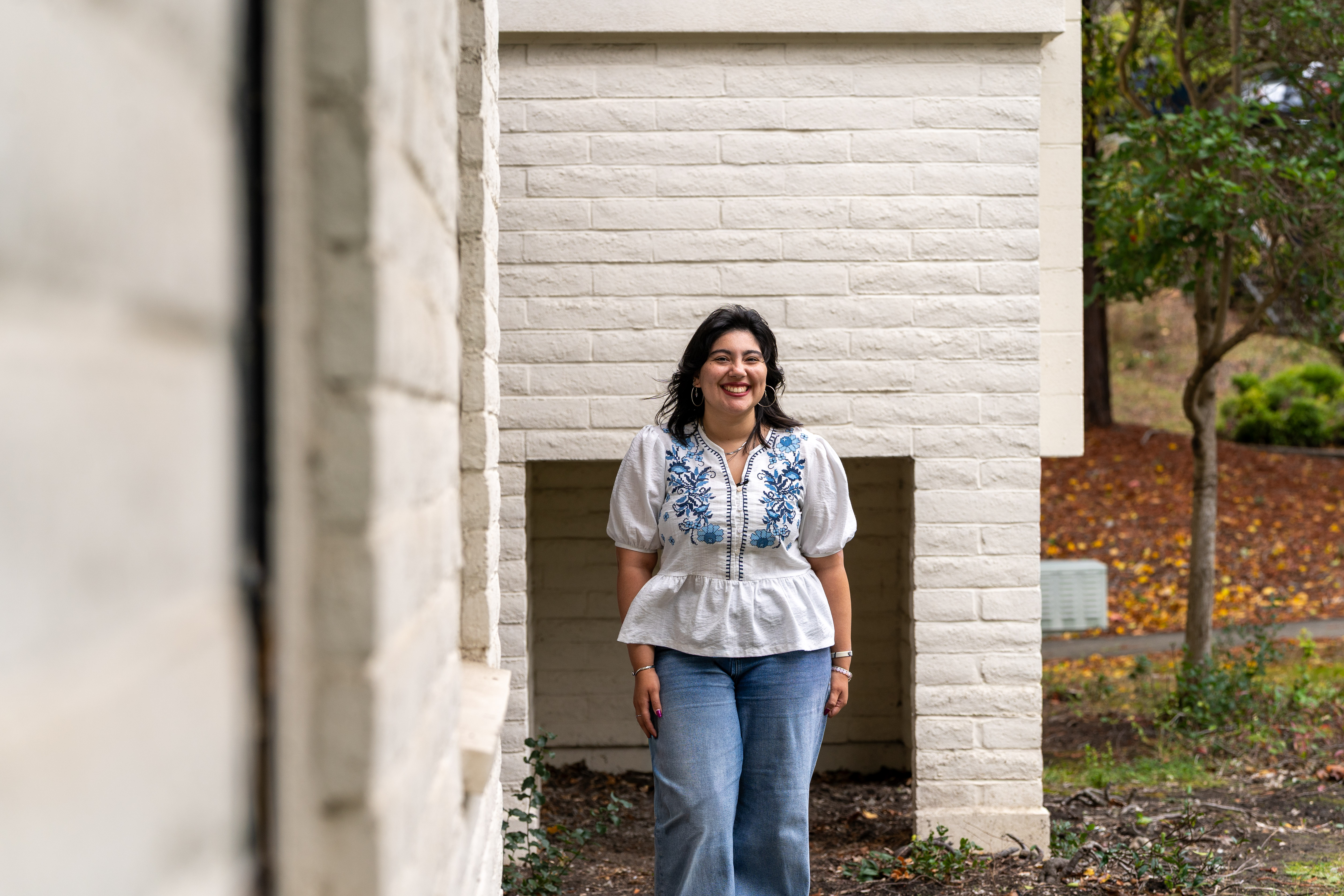 Cecilia Espinoza smiles in front of a campus building