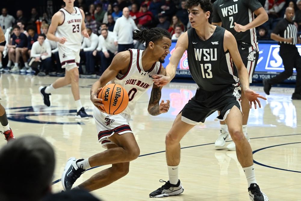 Basketball player Mikey Lewis drives against WSU in January 2026