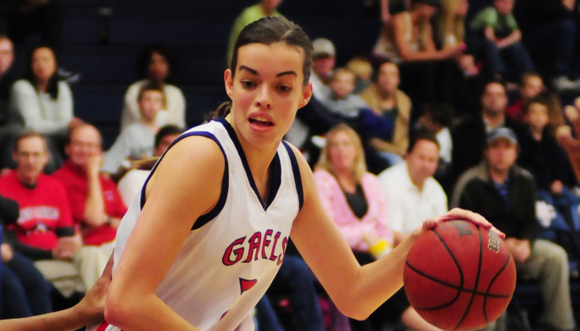 Women's Basketball player Louella Tomlinson dribbles the ball