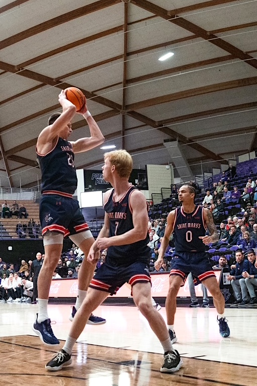 Basketball players Paulius Murauskas, Joshua Dent, and Mikey Lewis on the court at Portland in January 2026
