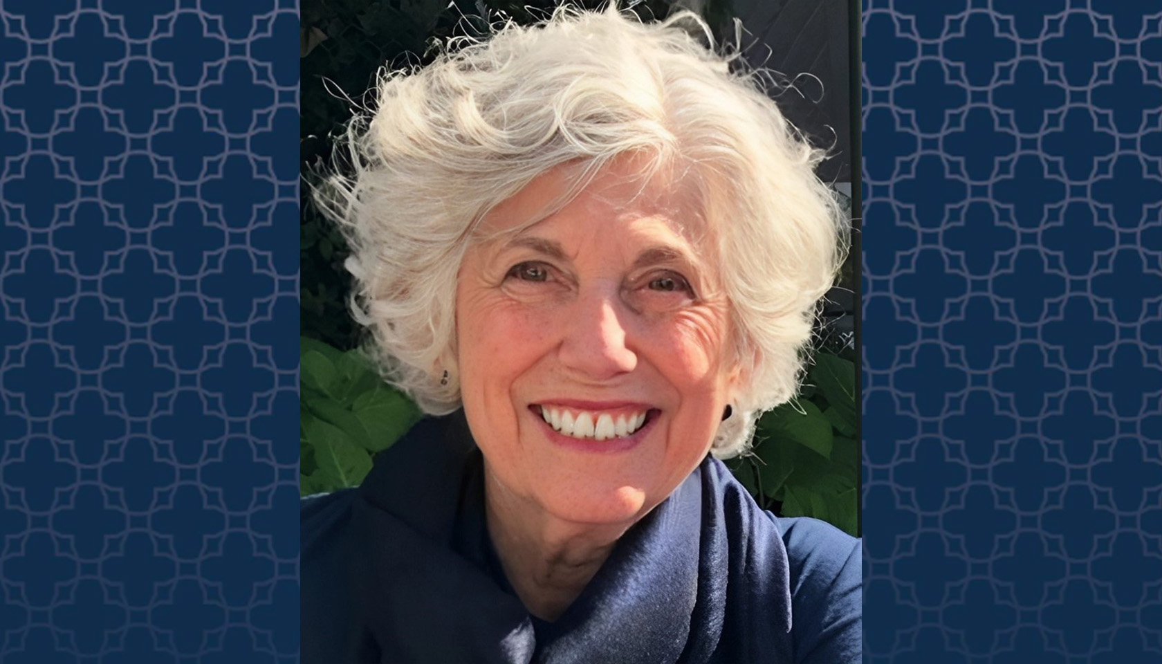 Dr. Maria O'Rourke headshot with a blue patterned background