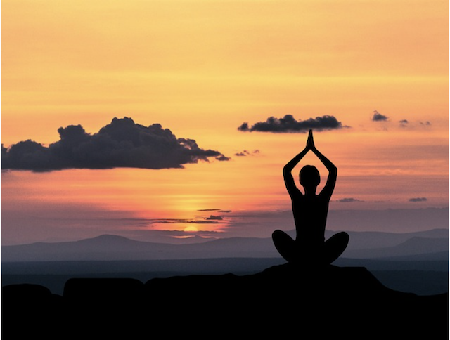 Yoga pose silhouette in sunset