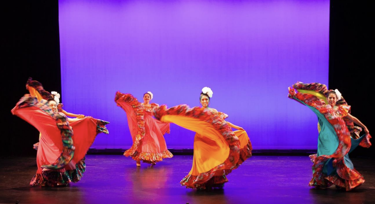 four girls performing ballet folk dance on stage