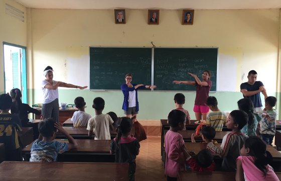 A group of students leading elementary schoolers in a class exercise