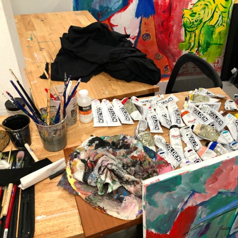 table with tubes of paint and brushes and paint covered rags
