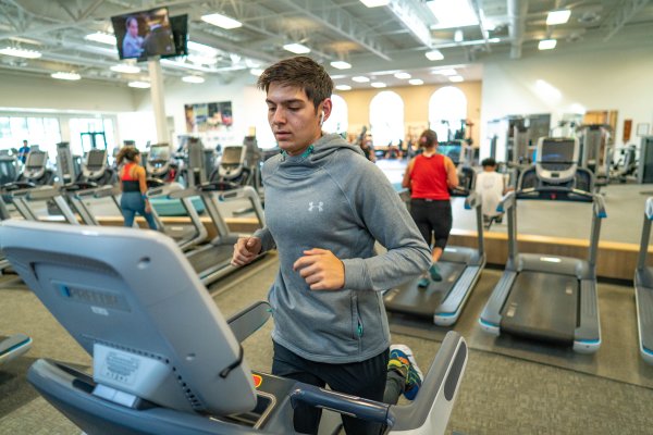 a man jogs on a treadmill inside the Rec Center