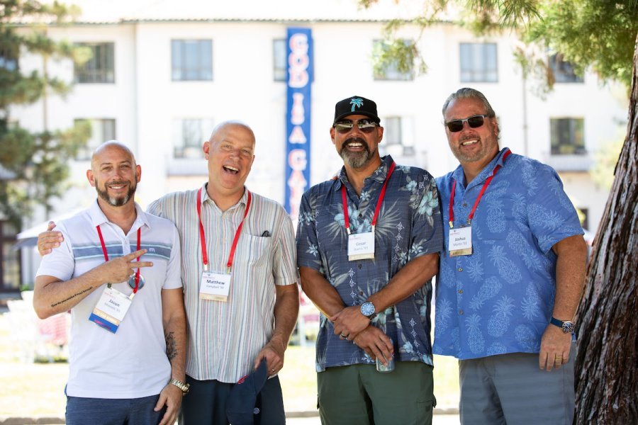 Four men from the class of 1993 smile in front of De La Salle Hall during Reunion 2023