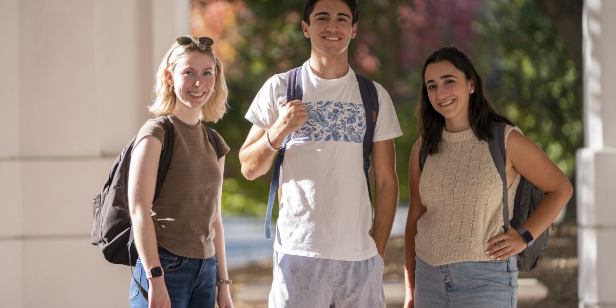 3 students walking on campus with backpacks