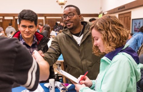 four people shaking hands and checking boxes