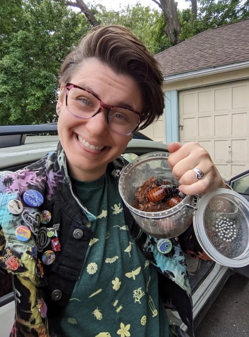 Abbey Hayes holds a small terrarium with insects