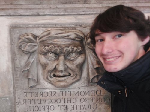 Chris Baker posing with stone sculpture face 