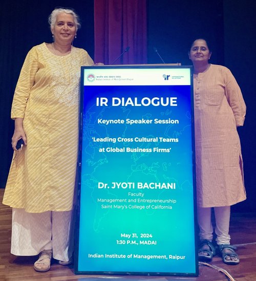 Jyoti Bachani and a colleague posing onstage at 2024 keynote address at IIM Rapuir