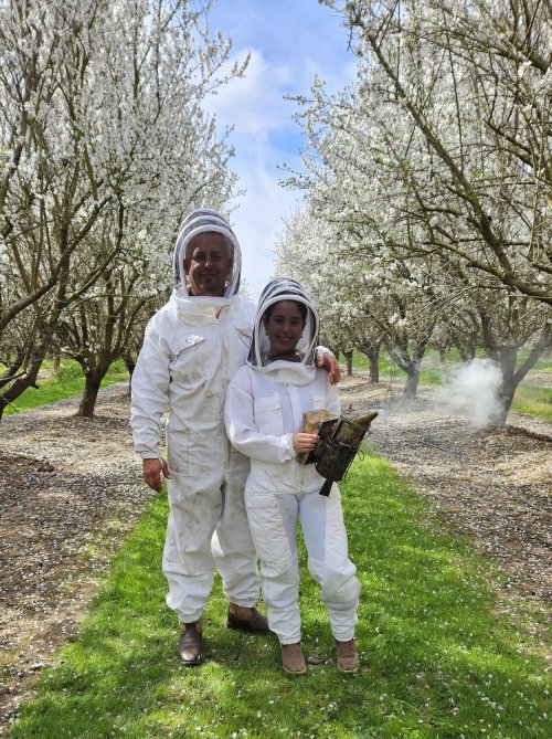 Alejandra Perez and her father in beekeeping suits