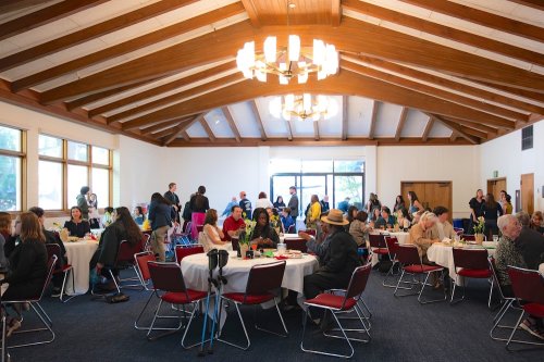 People seated at tables for Disability & Neurodiversity Graduate Celebration in May 2026