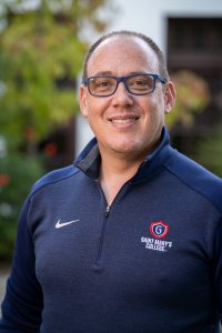Gabe Welcher smiling in front of a campus building