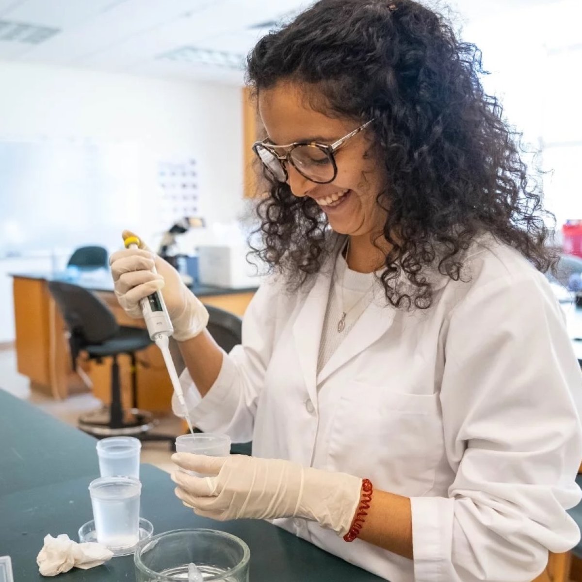 Student in a lab coat conducting an experiment