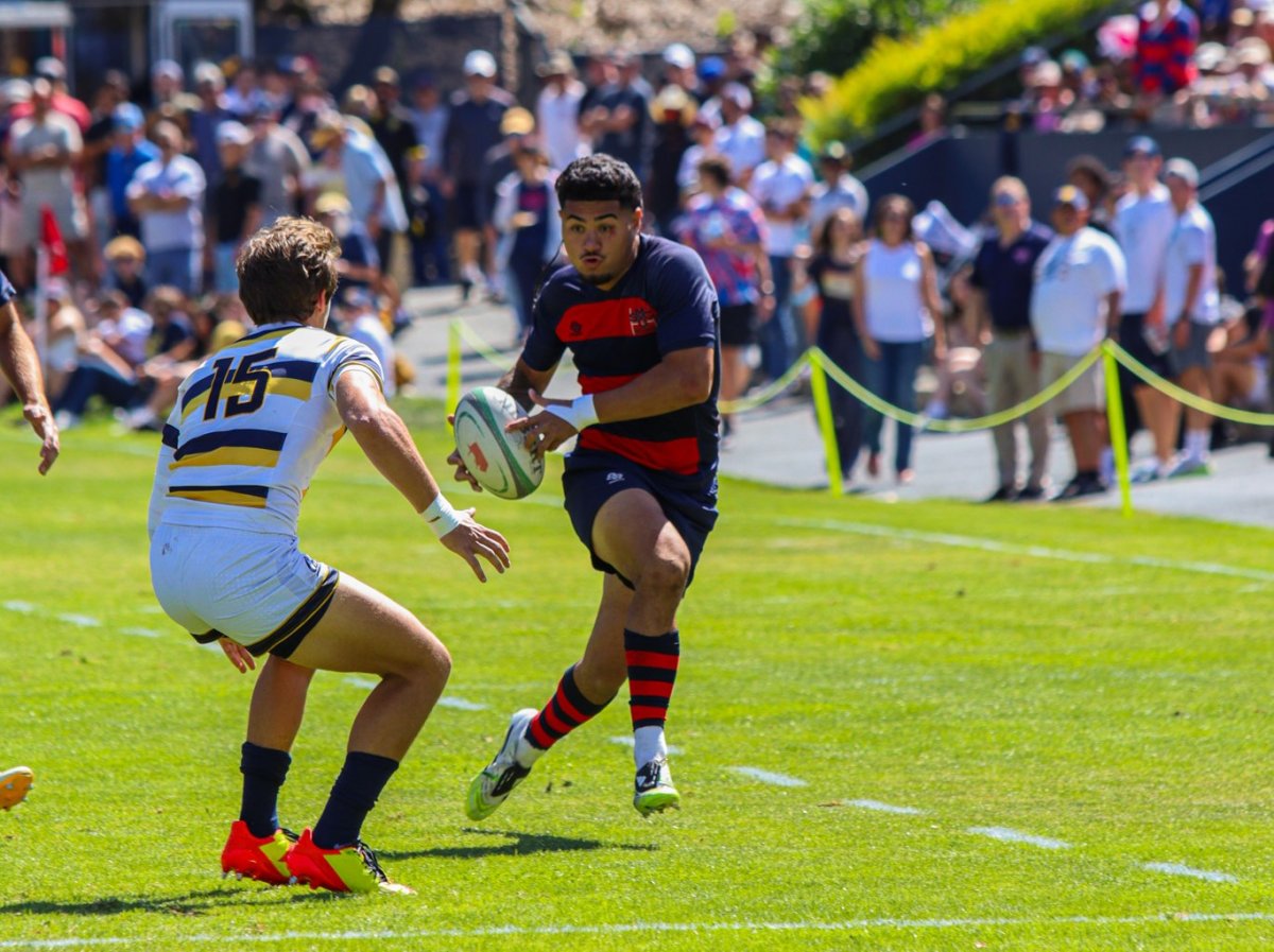 Saint Mary's player Iosefa Toiaivao runs with the rugby ball as he attempts to evade a UC Berkeley rugby player.