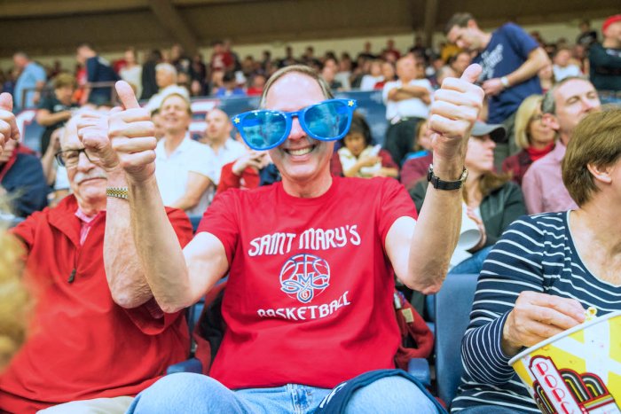 A man gives thumbs up while wearing funny oversized sunglasses