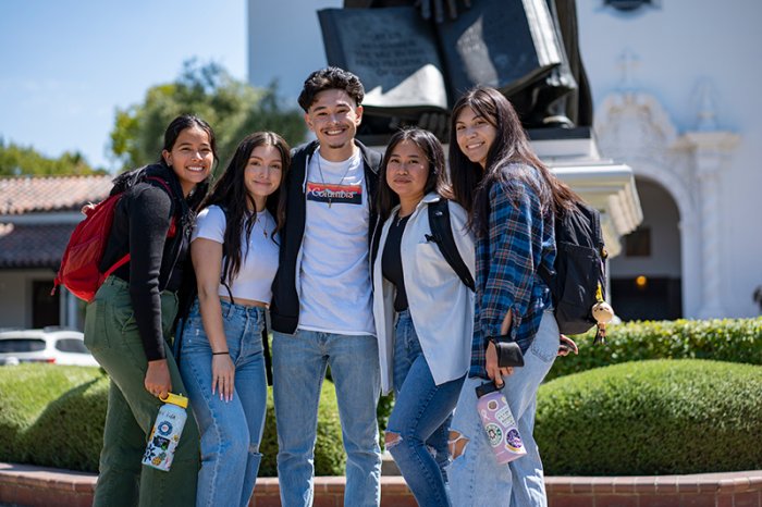 five students in front of statue outside