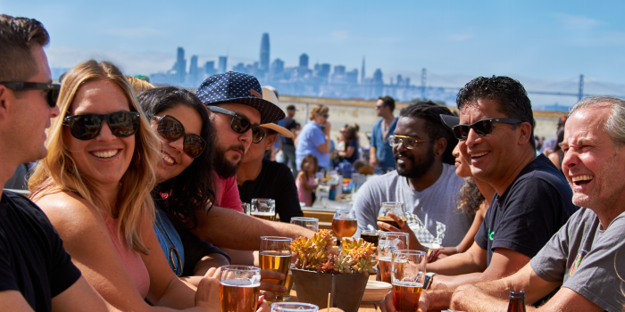 A group of people at a table with the San Francisco skyline in the background