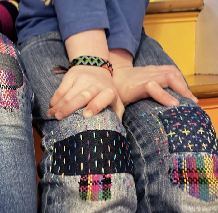 colorful sewn patchs on the knees of jeans