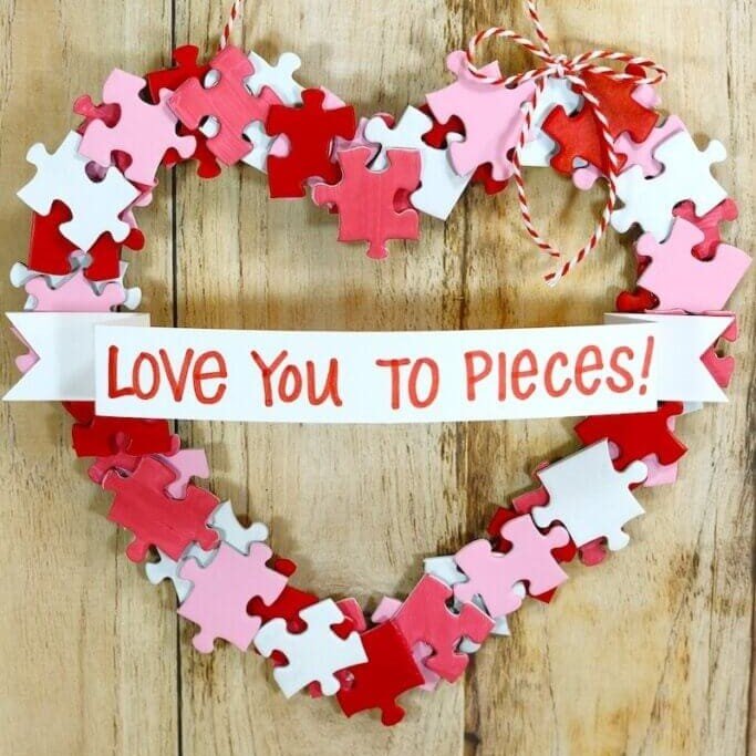 pick, white, and red puzzle pieces collaged into a heart shape