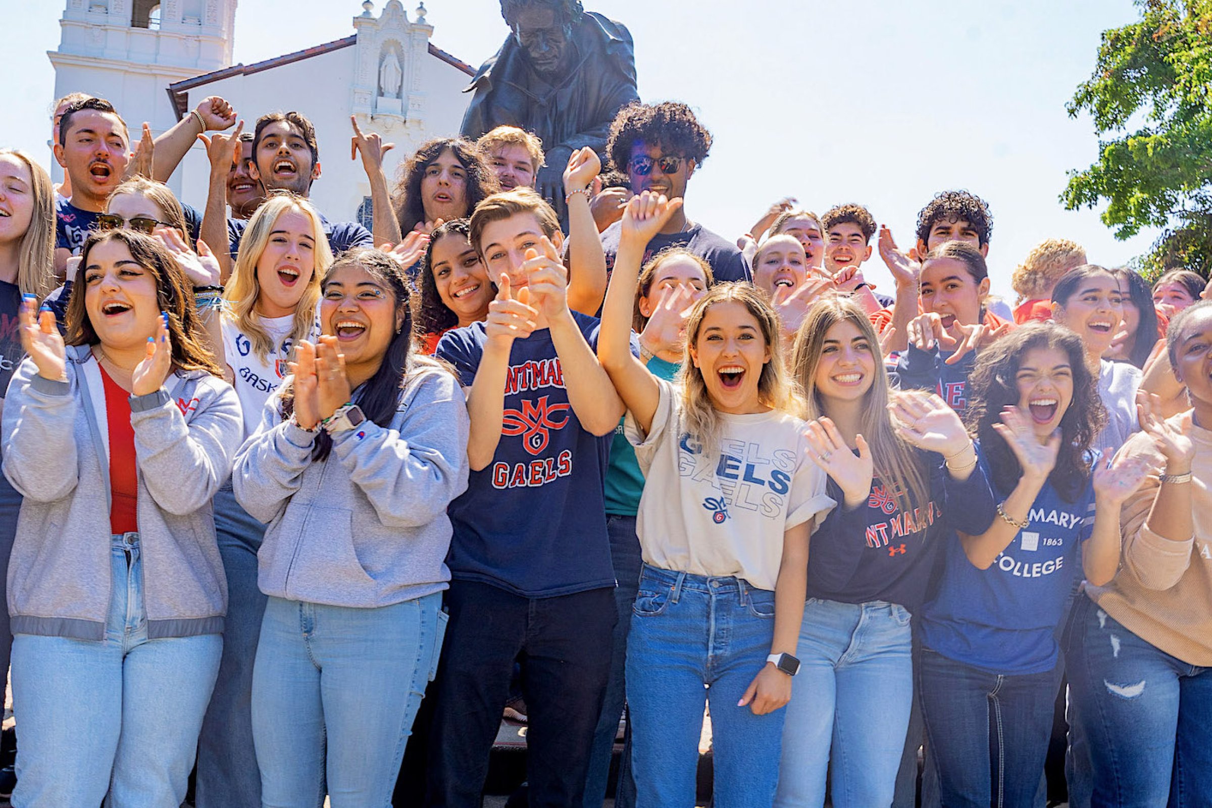 students in front of statue and chapel at Saint Mary's fall 2023