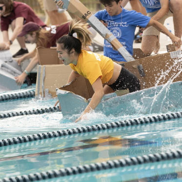 Students in cardboard canoe race for the First Year Olympic event