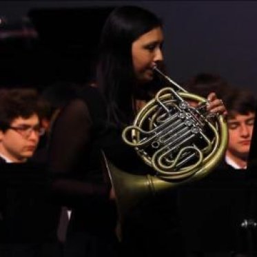A musician plays a French Horn solo