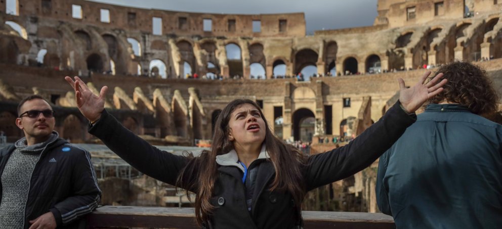 Student holding her arms up inside the roman colosseum