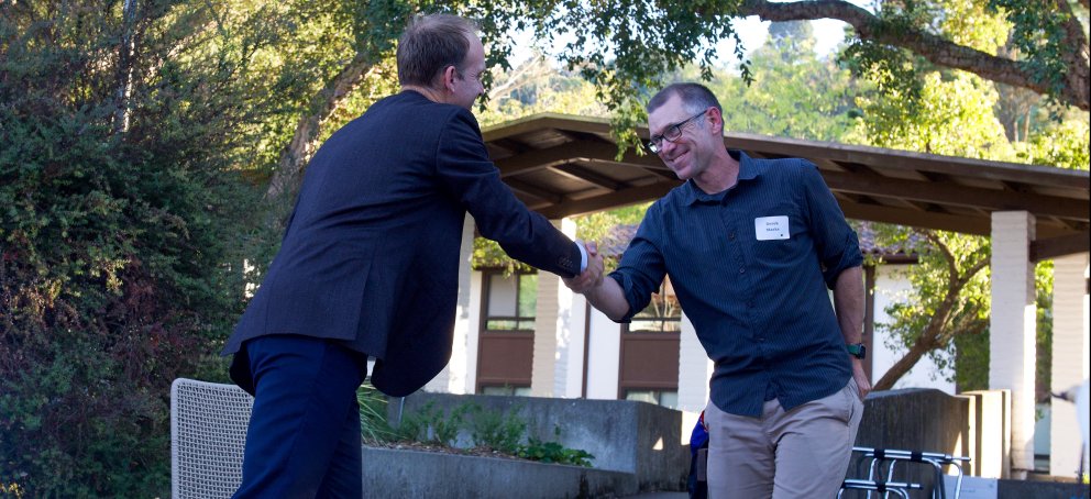 Corey shakes hands with faculty member