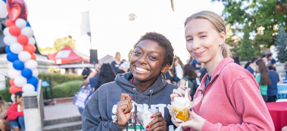 students smiling and eating ice cream at a bbq