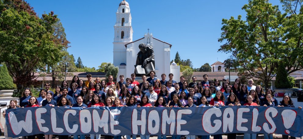 Students in front of Chapel with sign WELCOME HOME GAELS