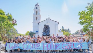 Students in front of SMC Chapel with sign WELCOME HOME, GAELS
