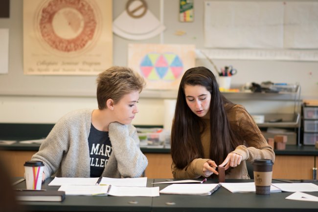 Two students sitting at a desk discussing math