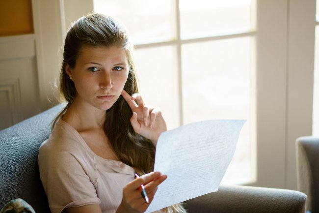 Writer holding a piece of paper in the Writing Center.