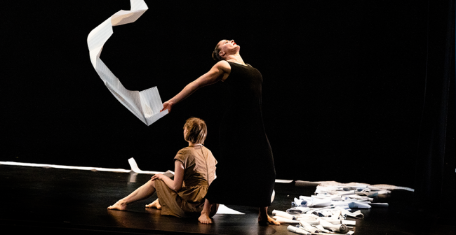 Two dancers with paper on stage