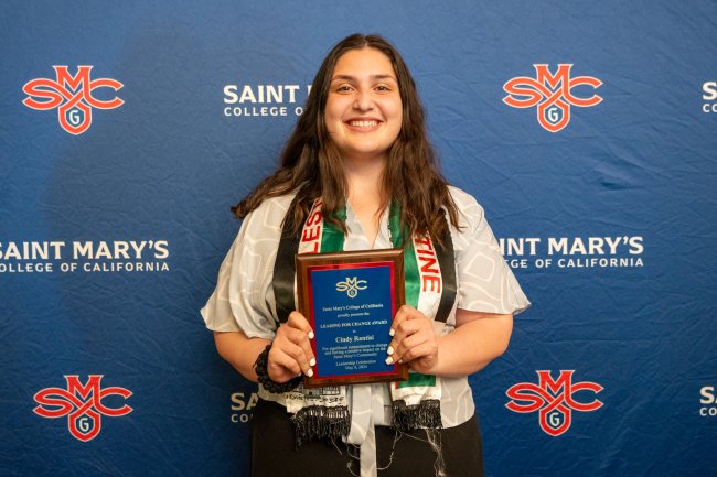 Cindy Rantisi holds up a plaque for 2024 Student Leadership Awards
