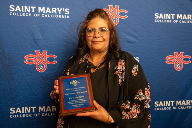 Karla Henriquez holds up a plaque for 2024 Student Leadership Awards