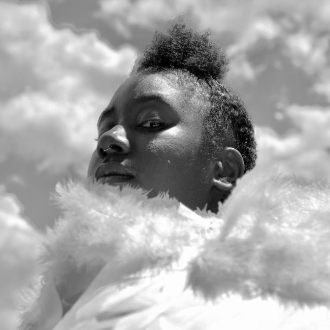 A b&amp;w photo of dancer Riyadah Mutakabbir, wearing white